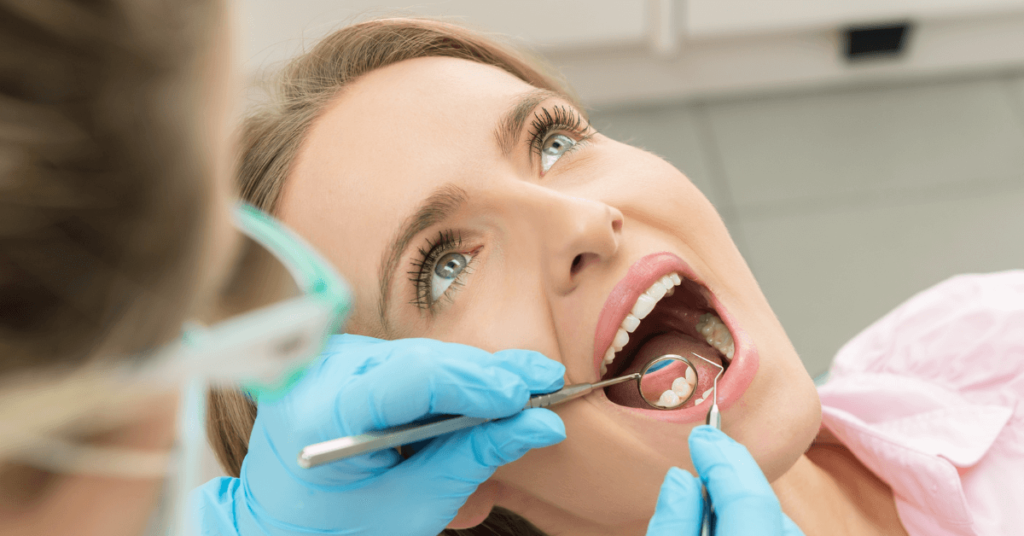 Žena s otvorenými ústami pri prehliadke zubov